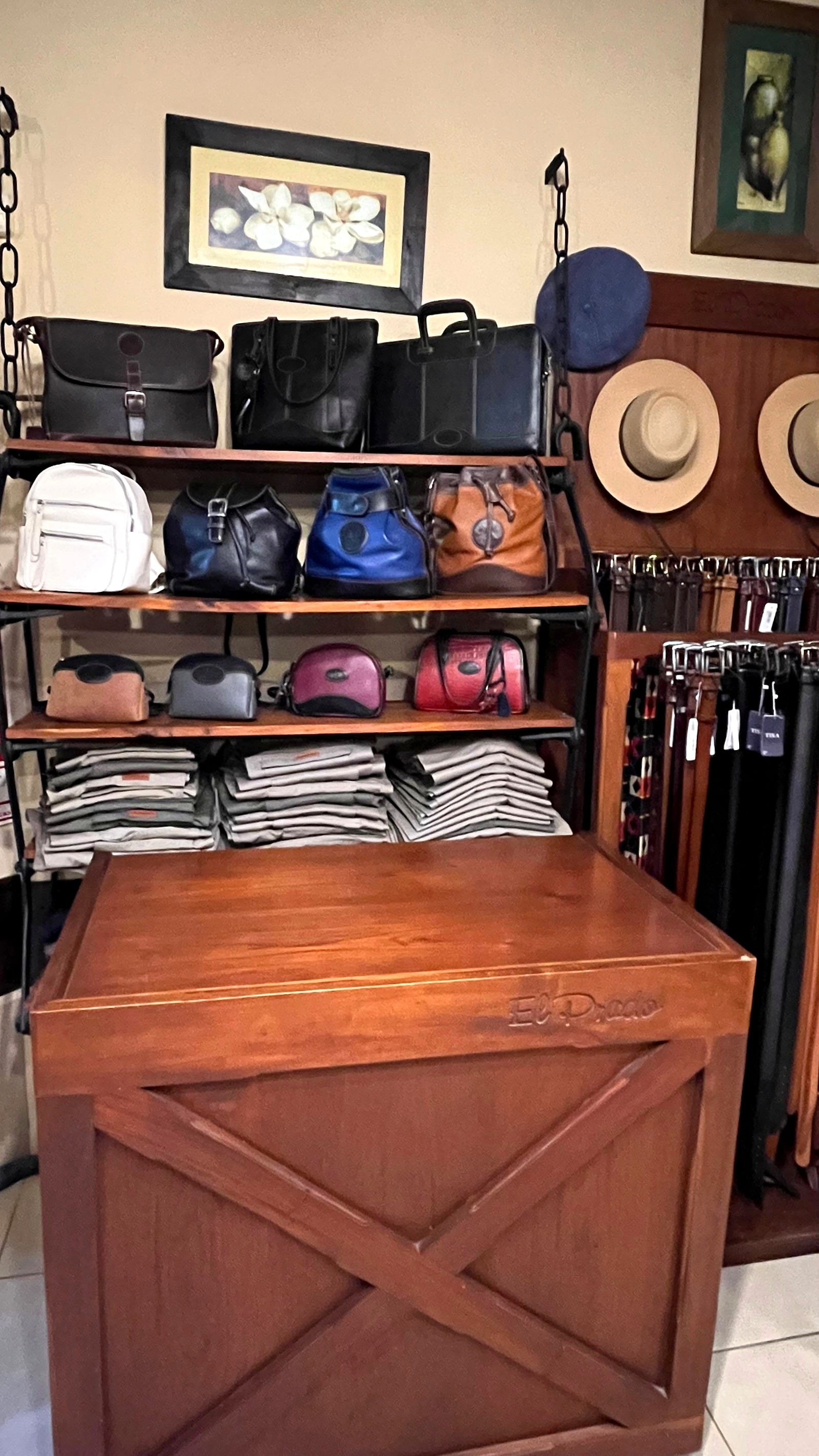 Estantes con carteras, bolsos y mochilas en negro, blanco, azul y suela.